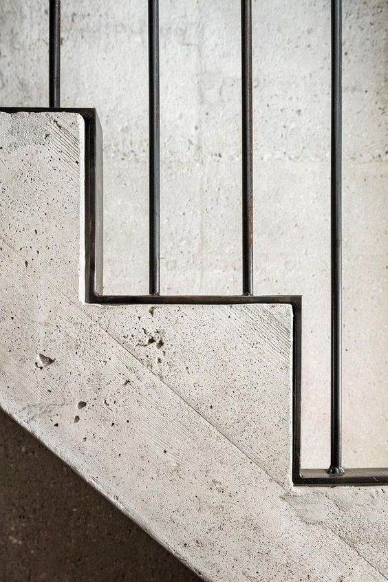 Betonnen trap met zwarte stalen balustrade langs treden