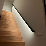 Rechthoekige stalen design trapleuning met ledverlichting bij eikenhouten trap