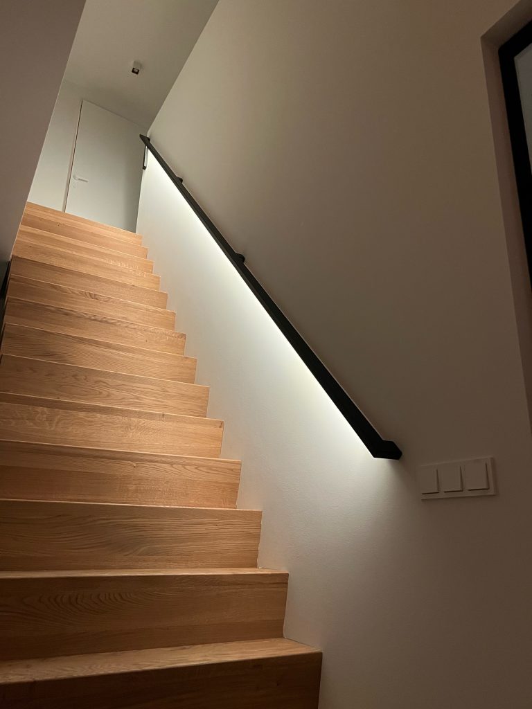 Rechthoekige stalen design trapleuning met ledverlichting bij eikenhouten trap