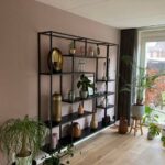 Op maat gemaakte stalen kast met asymmetrische vakken voor accessoires in woonkamer