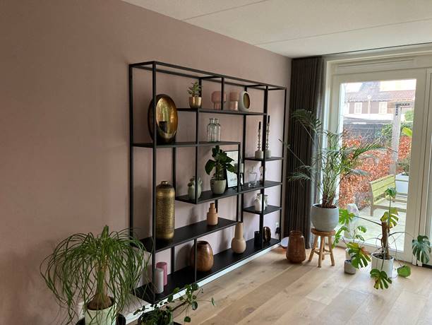 Op maat gemaakte stalen kast met asymmetrische vakken voor accessoires in woonkamer